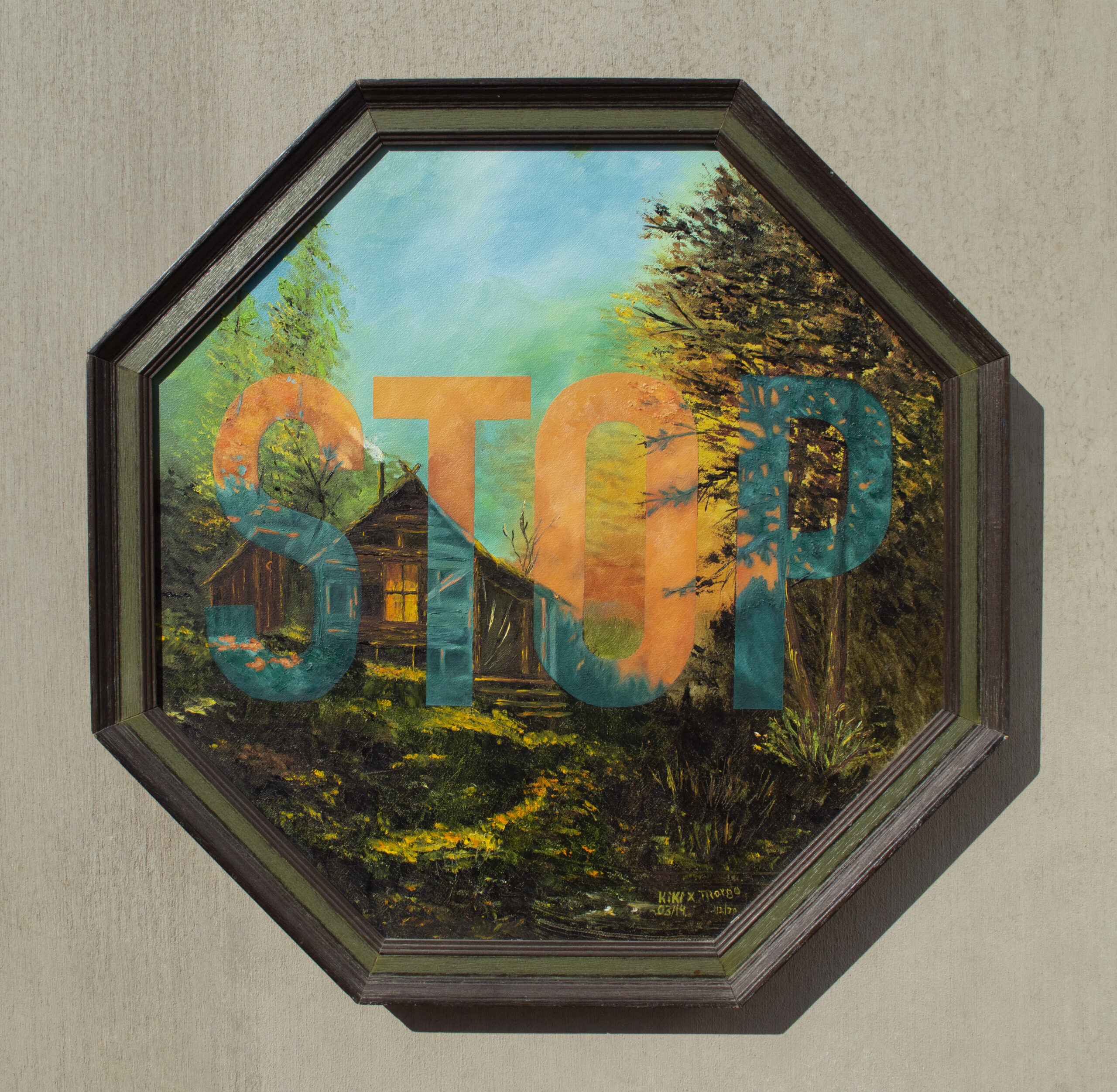 A octagon shaped frame with a painting of a cabin in the woods with a sunset in the background with the word stop large in the center of scene.