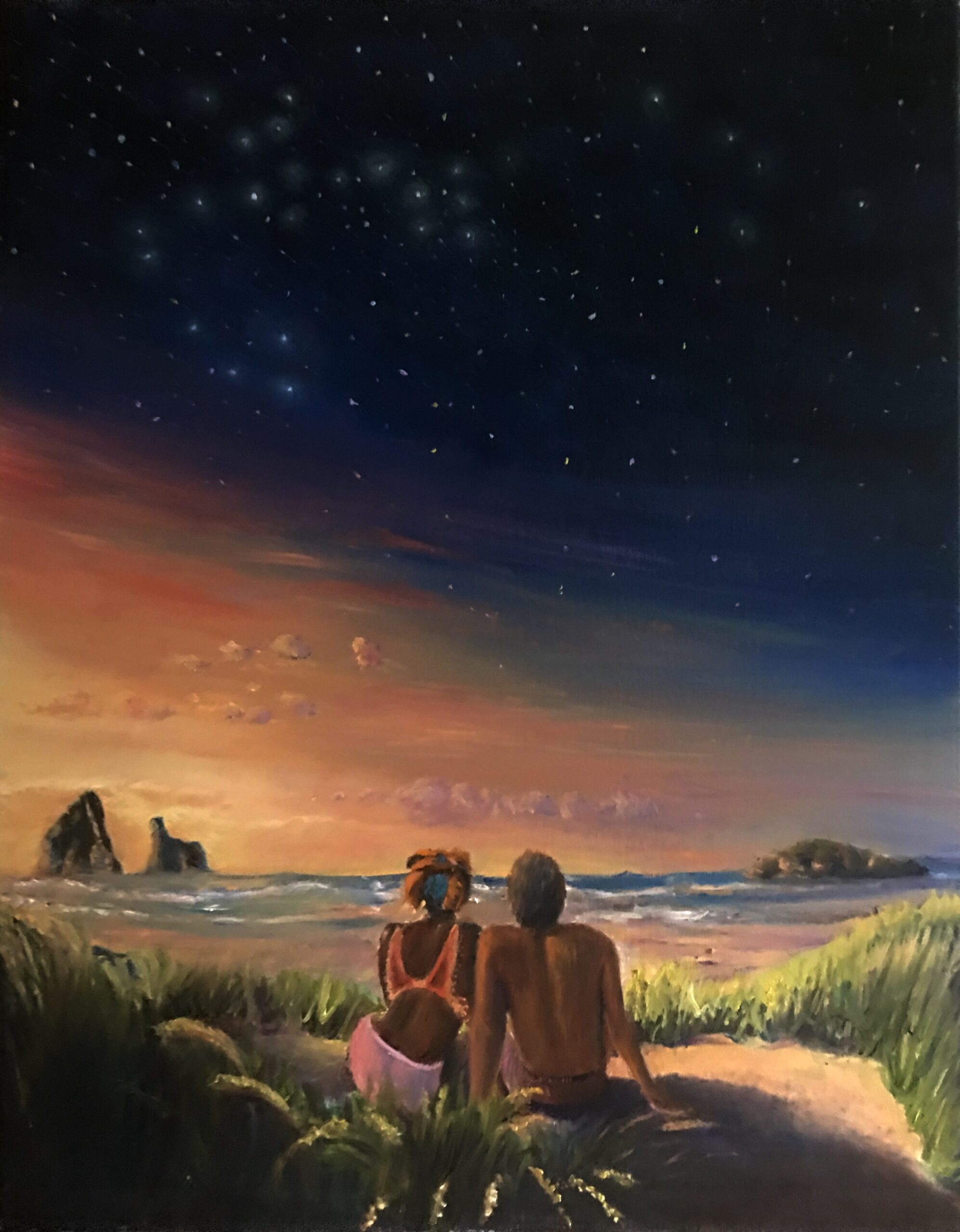 Two people sitting in front of the sea next to each other during the sunset with grass and sand around them and a star filled sky above them.